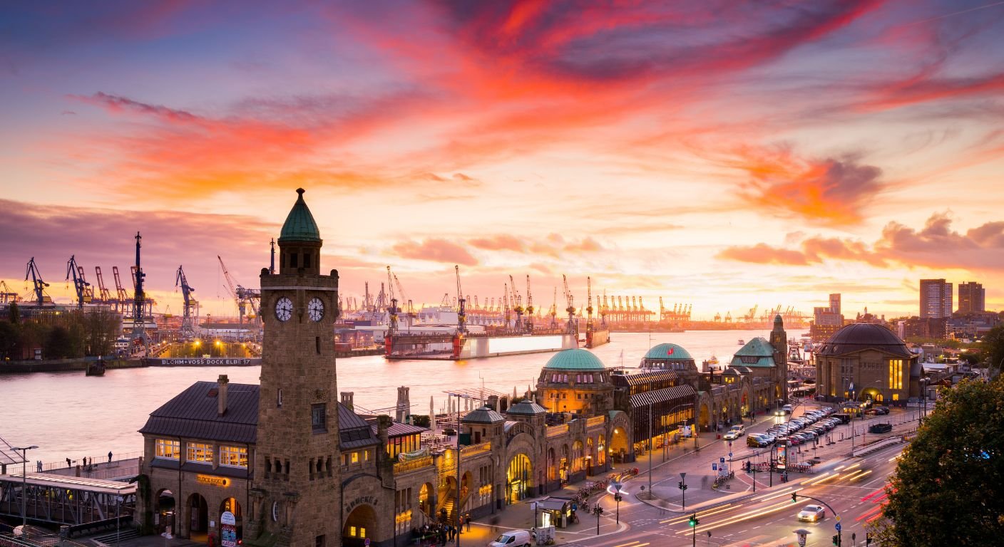 Container ships and cranes at a port at sunset, the kind of freight that needs a United States Importer of Record